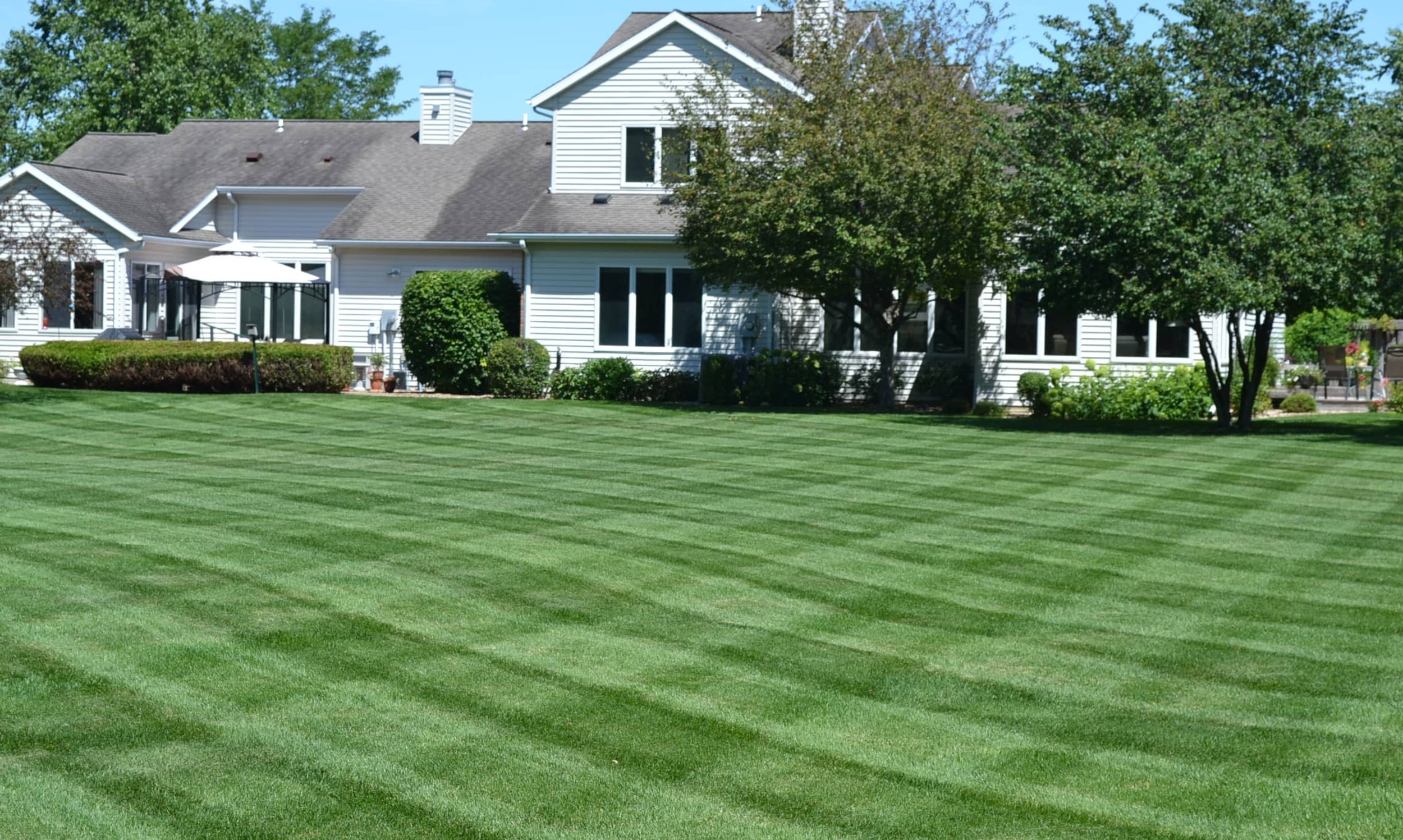 A beautifully maintained lawn with precise mowing stripes, suggesting a high level of lawn care and a desirable aesthetic for a residential property.